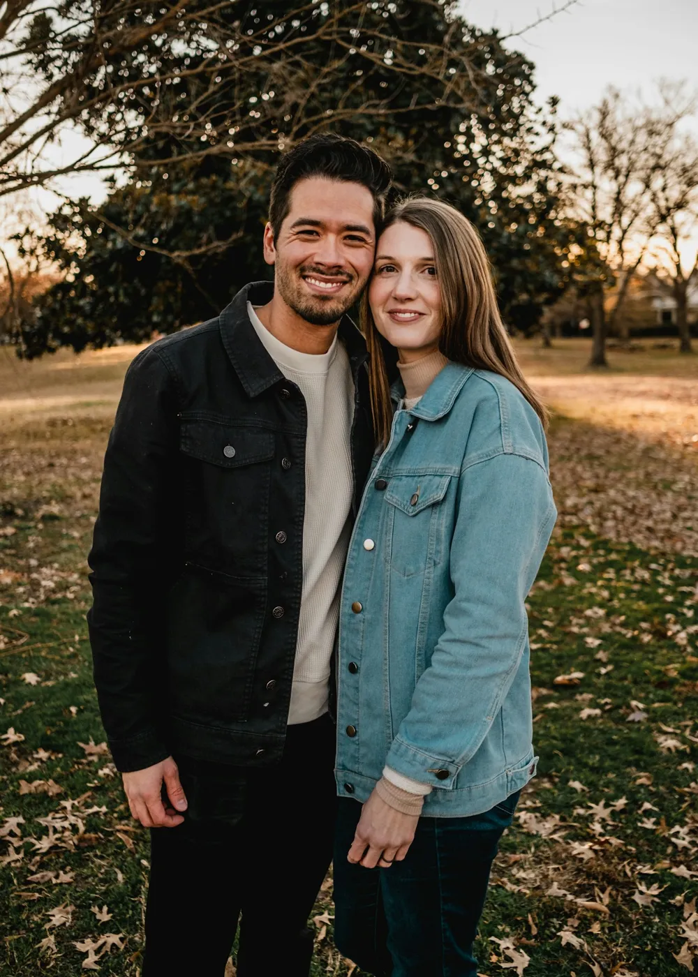 Un homme et une femme souriants, côte à côte en extérieur